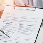 woman candidate and hr manager employer holding cover letter during job interview sitting in office